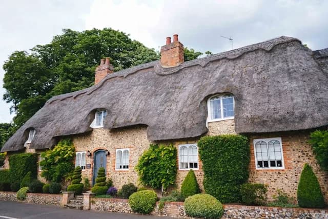 Gîte normand traditionnel entouré de verdure.