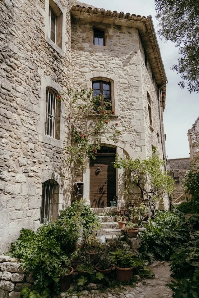 Maison rurale en pierre entourée de végétation.