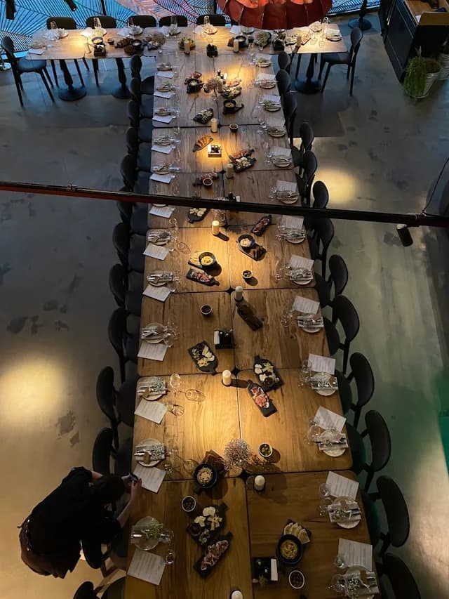 Grande table dressée pour repas de groupe.