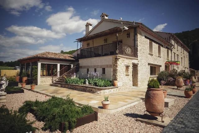 Grand gîte de vacances en pierre avec terrasse ensoleillée.