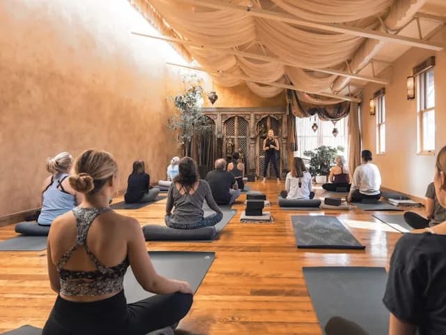 Groupe en séance de yoga dans une salle chaleureuse.